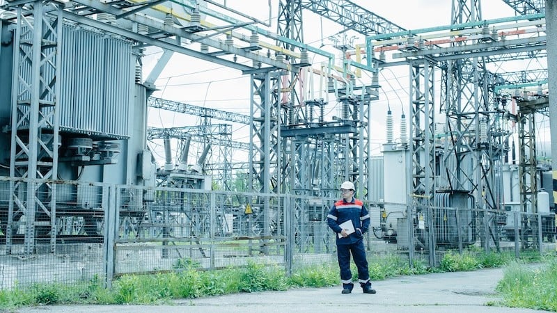 Shown here, an engineer inspects the modern equipment of an electricalsubstation before commissioning. Image from Adobe Stock (licensed).