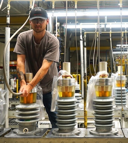 Worker at Hitachi Energy's transformer component factory in Alamo, TNassembling bushings that connect equipment, like transformers, to the grid.