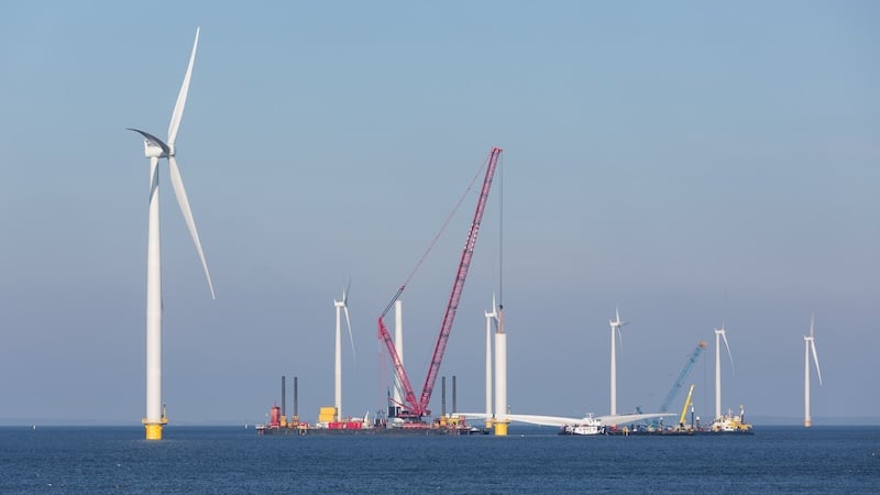 A large crane is constructing an offshore wind farm